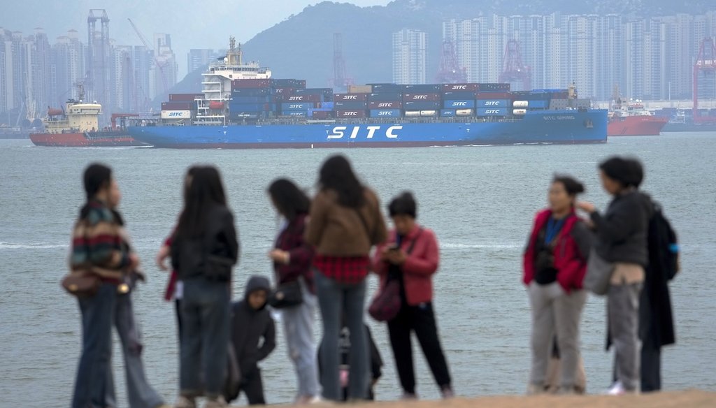A container ship passes tourists in Xiamen, a city in southeast China's Fujian province. (AP)